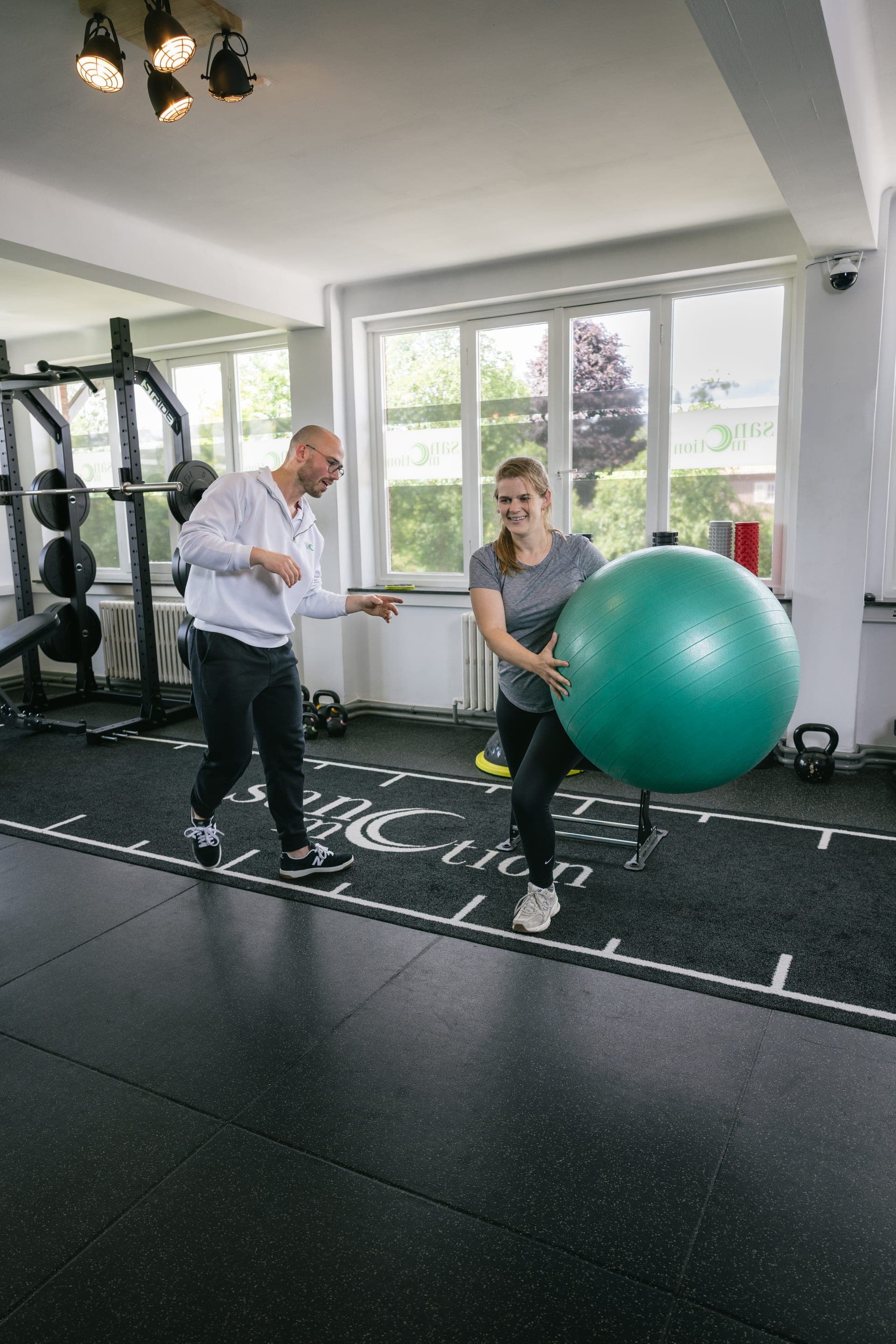 Personal trainer begeleidt een cliënt bij krachttraining in de Private Gym